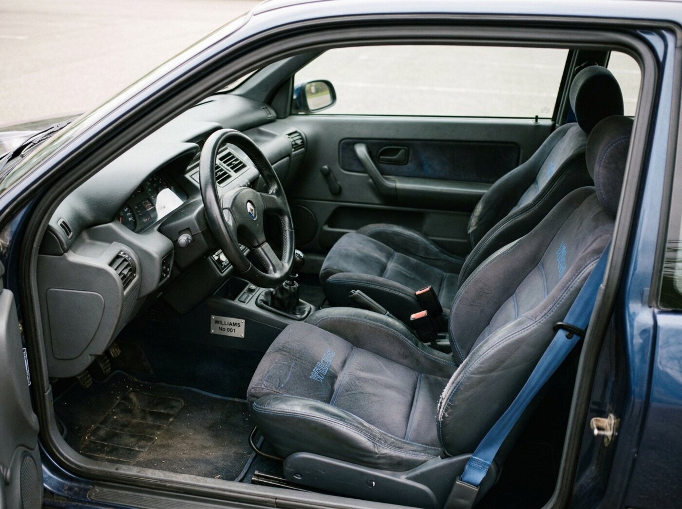 Intérieur Clio Williams : sièges sport spécifiques, ceintures bleues et plaque numérotée sur la console