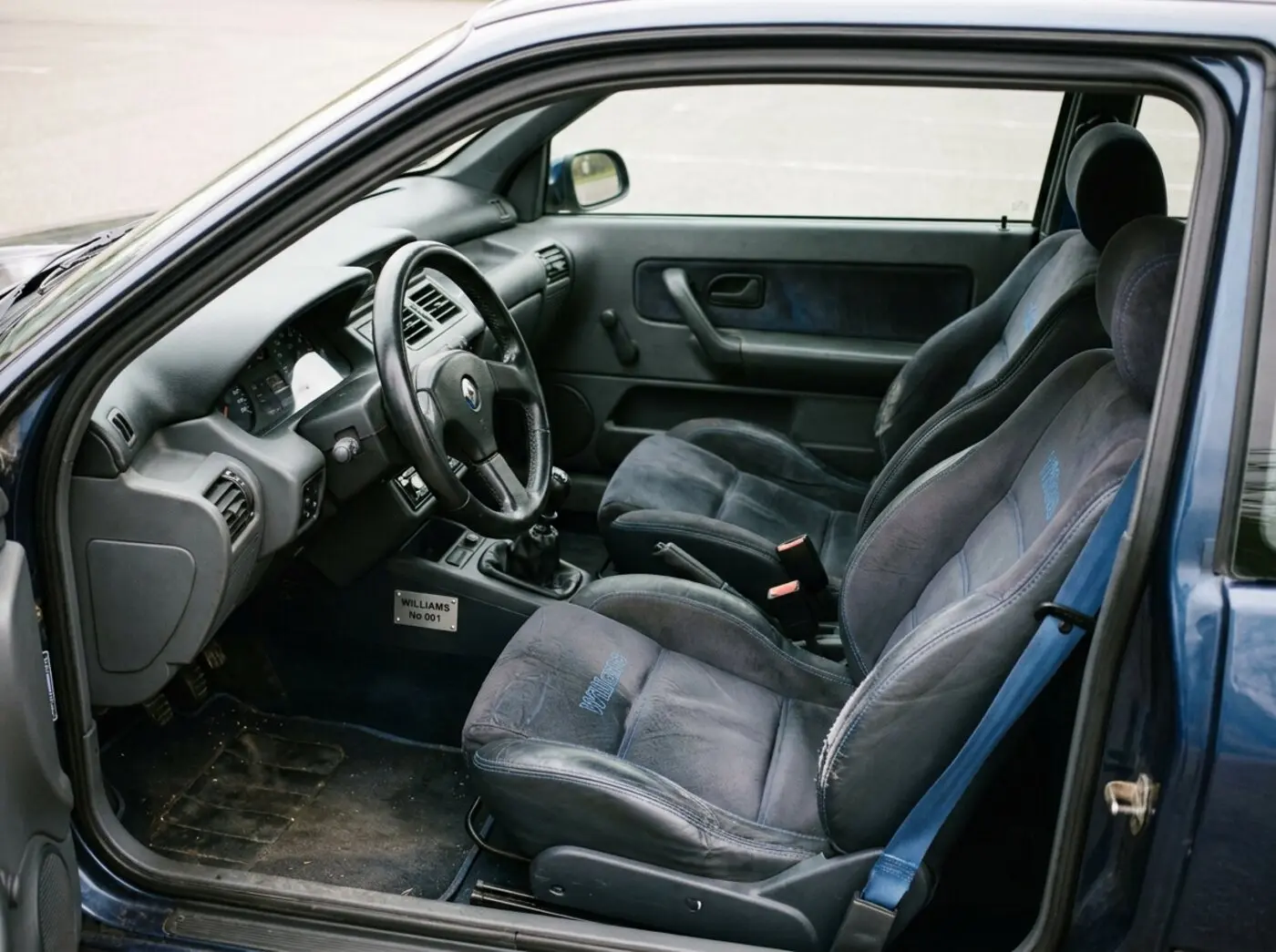 Intérieur Clio Williams : sièges sport spécifiques, ceintures bleues et plaque numérotée sur la console