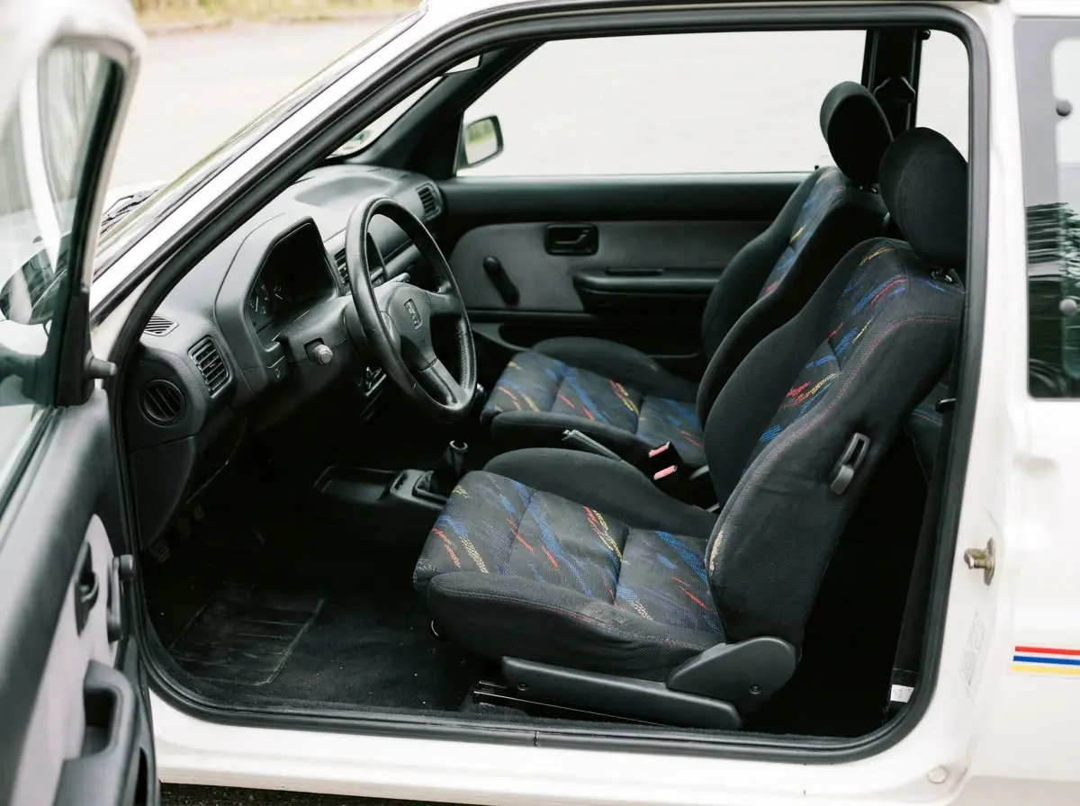 Intérieur Peugeot 106 Rallye : sièges baquets en tissu à motifs, volant trois branches, tableau de bord sobre des années 90