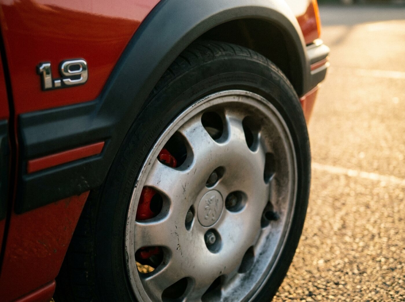 Détail Peugeot 205 GTI : jante pepperpot et monogramme 1.9 sur l'élargisseur d'aile