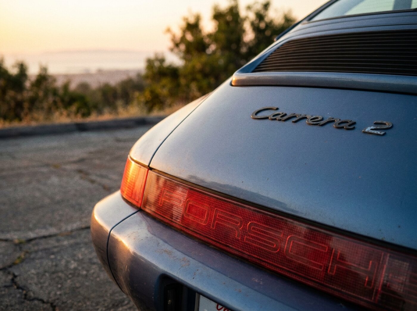 Détail arrière Porsche 964 : bandeau réflecteur avec lettrage PORSCHE et badge Carrera 2