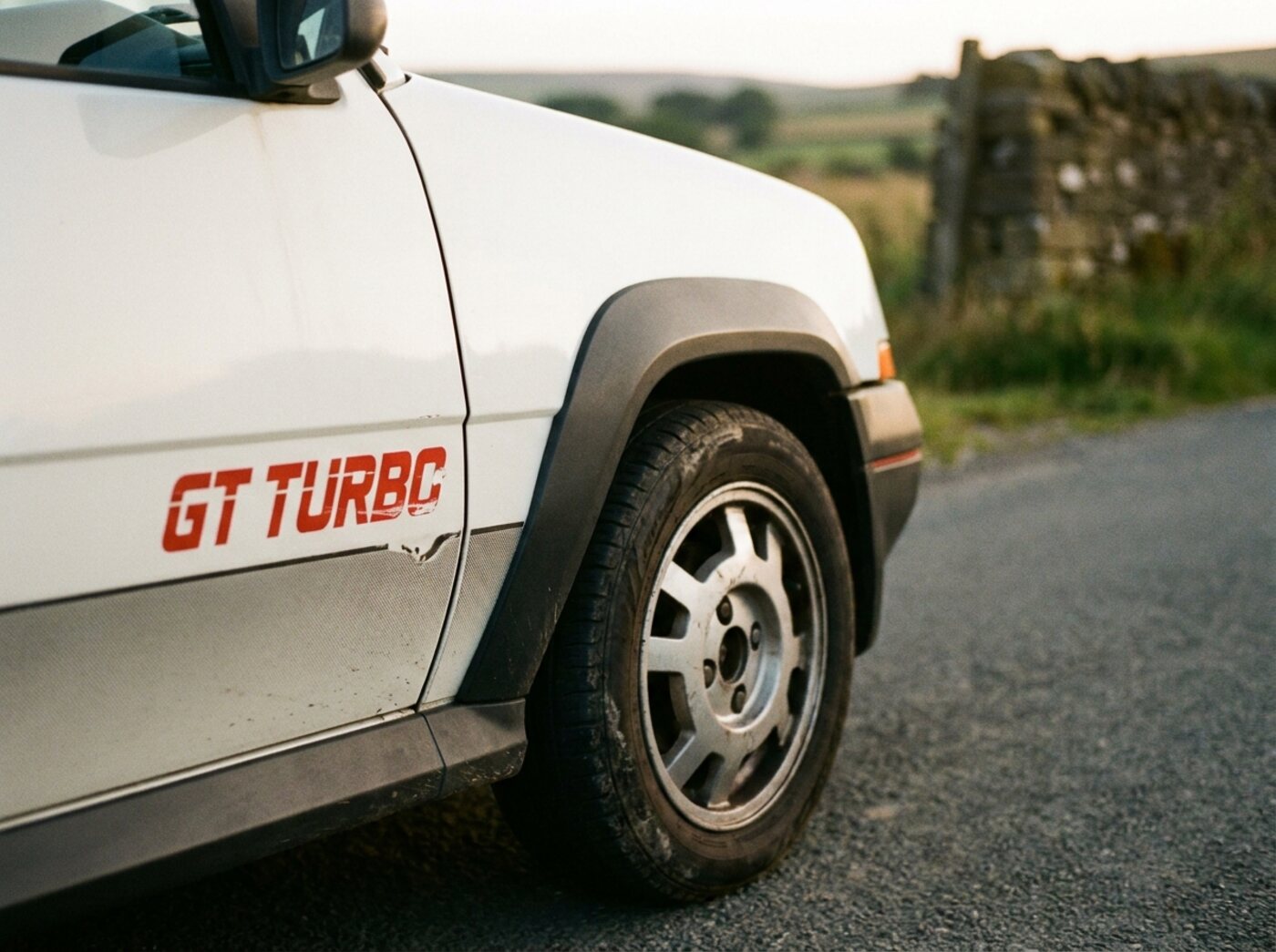 Détail R5 GT Turbo : sticker GT Turbo rouge sur carrosserie blanche et extension d'aile