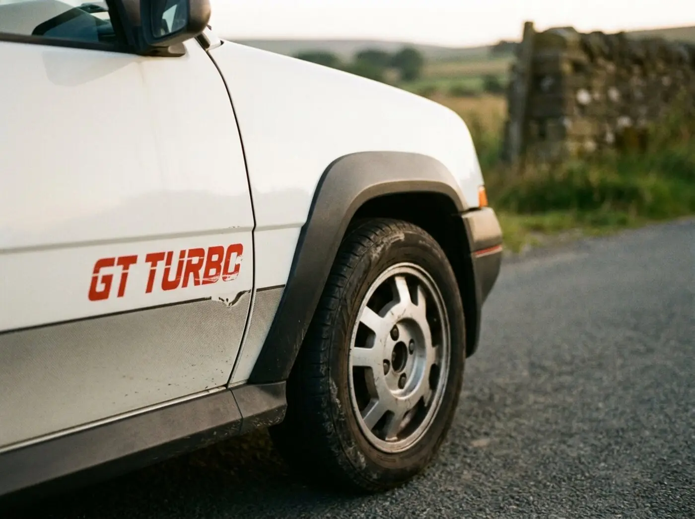 Détail R5 GT Turbo : sticker GT Turbo rouge sur carrosserie blanche et extension d'aile