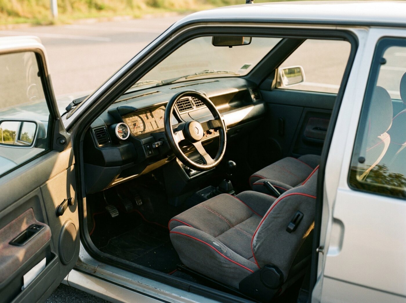Intérieur Renault 5 GT Turbo : sièges sport à liseré rouge, petit volant trois branches et manomètre de pression